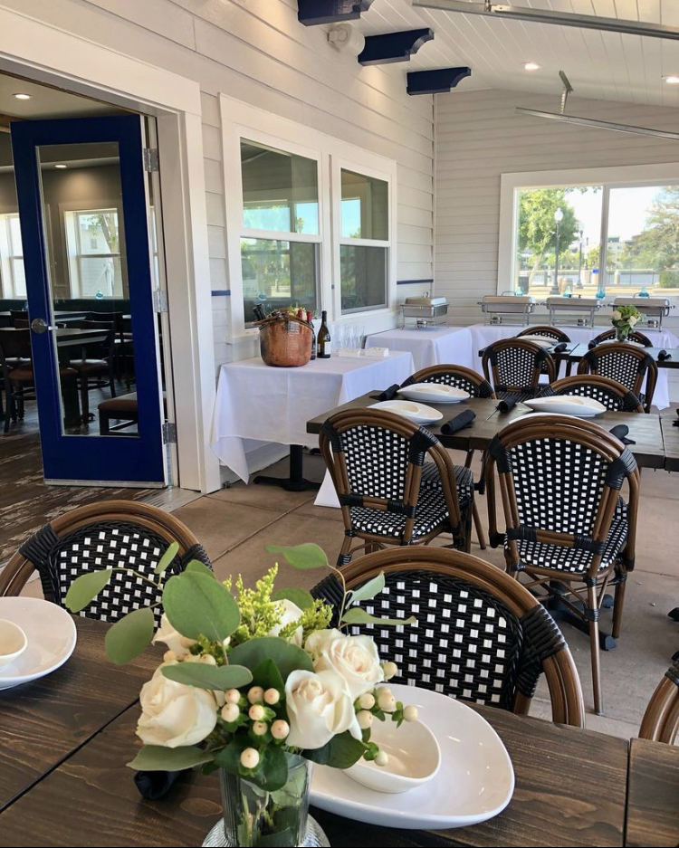 The outdoor padio table setup with flowers on tables.